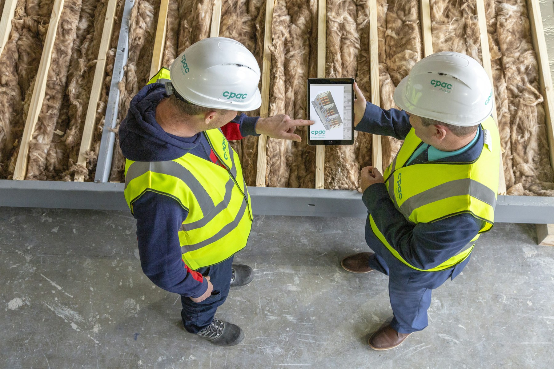 Construction workers reviewing project information on a tablet